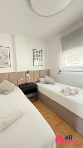 two beds in a white room with a window at Casa Buena Vista con piscina y ascensor in Cullera +103 photos