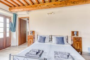 a bedroom with a large bed with blue pillows at La Quinta Decima Bioagriturismo in Fattoria Spedaletto