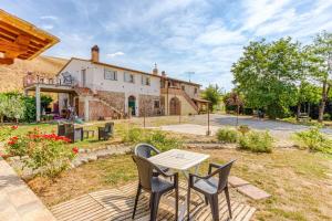 a table and chairs in front of a house at La Quinta Decima Bioagriturismo in Fattoria Spedaletto