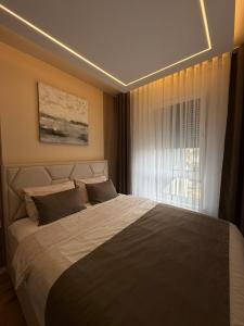 a bedroom with a large bed and a window at Emma Luksuzni apartman Tuzla Musique in Tuzla
