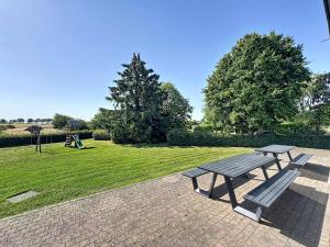 a picnic table and a bench in a park at Le Refuge du Trappeur in Hour