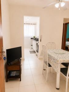 a kitchen and dining room with a table and a television at Cantinho Xodó in Capitólio