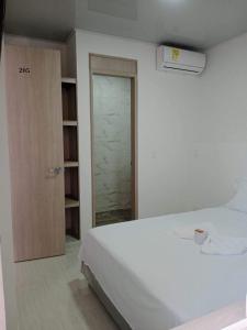 a white bedroom with a bed and a closet at hotel brb nature acacias in Acacías +5 photos