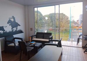 a restaurant with a table and chairs and a large window at hotel brb nature acacias in Acacías