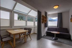 ein Zimmer mit Tisch, Stühlen und Fenstern in der Unterkunft Klaushof in Ischgl