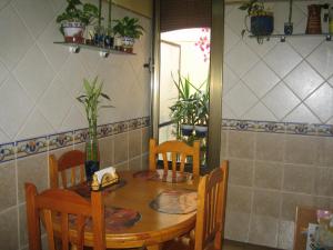 tavolo e sedie in cucina con tavolo e sedie a sdraio di Pension Alamar a Barcellona