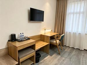 a hotel room with a desk and a tv at AERON hotel in Yakkasaray