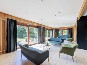 a living room with couches and chairs and windows at Le Refuge du Trappeur in Hour
