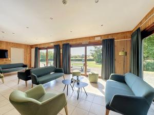 a living room with blue couches and chairs at Le Refuge du Trappeur in Hour