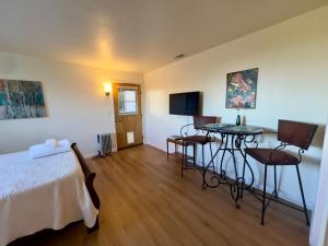 a bedroom with a bed and a table and chairs at Charming studio one mile from beach in Aptos