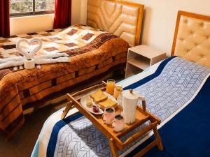 a hotel room with a tray of food on a bed at Hotel Golden La Paz in Callampaya