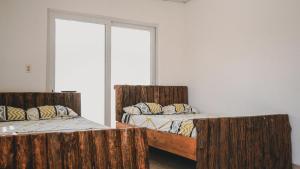 two beds in a room with wooden posts at Casa Troya in Nueva Gorgona +1 photo