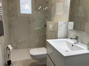 a white bathroom with a sink and a toilet at Casa Mezzana in Valle-di-Mezzana