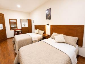 a hotel room with two beds and a desk at Suite Tarqui en el Centro Histórico in Cuenca