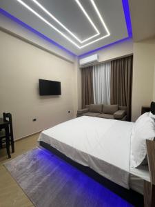 a bedroom with a large white bed and a couch at Skampa Apartment in Elbasan +5 photos