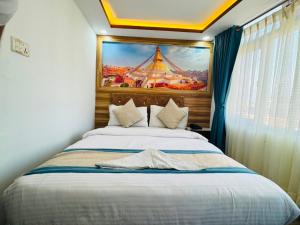 a bedroom with a bed with a painting on the wall at Hotel Delite in Thapathali