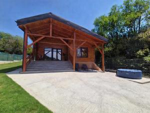 a large wooden pavilion with a staircase in a park at Luca`s Chalet Ocnele Mari in Ocnele Mari