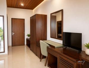 a room with a desk with a television and a mirror at Rainbow Seven Hotel in Negombo