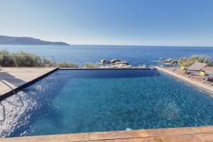 a swimming pool with a view of the ocean at Cala Di Mare Villa in Calvi
