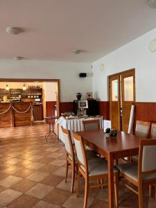 a dining room with a table and chairs and a kitchen at Marina Labe in Píšťany