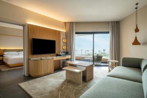 a hotel room with a bed and a flat screen tv at Taghazout Bay Marriott Resort in Taghazout