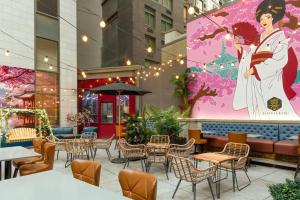 a restaurant with tables and chairs and a large mural at Four Points by Sheraton New York Downtown in New York