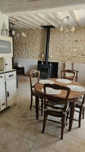 a kitchen with a wooden table and chairs and a stove at Holy Cottage in Sainpuits