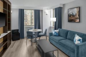a living room with a couch and a table at Four Points by Sheraton New York Downtown in New York