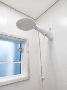 a shower head in a bathroom with a window at Hotel Pousada Garoupas in São Sebastião +22 photos