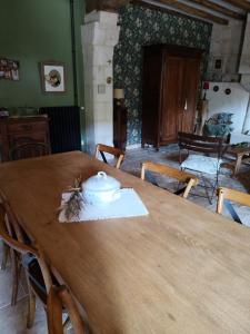 a wooden table with a pot on top of it at Le Logis Rabelaisien in Bourgueil +6 photos