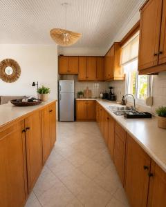 a kitchen with wooden cabinets and a stainless steel refrigerator at THEONprivehouse in Koinyra +23 photos