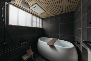 a bathroom with a tub and a sink and a window at Haku-ma 白間 in Kanazawa