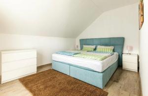 a bedroom with a bed with a blue headboard at Ferienwohnung Grüner Weg in Tecklenburg