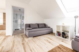 a living room with a couch and wooden floors at Ferienwohnung Grüner Weg in Tecklenburg