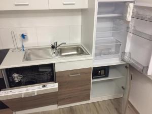 a kitchen with a sink and an empty refrigerator at Ferienwohnung Grüner Weg in Tecklenburg +7 photos