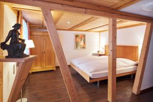 ein Schlafzimmer mit einem Bett und einer Holzdecke in der Unterkunft Hotel Appenberg in Zäziwil