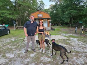 a man and a woman standing next to two dogs at Whippowill Cabin in Moss Point