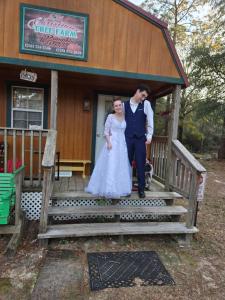a bride and groom standing on the steps of a building at Whippowill Cabin in Moss Point