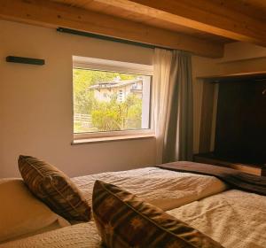 a bedroom with two beds and a window at B&B Te Nìf in Predazzo +10 photos