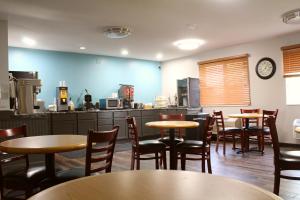 a restaurant with tables and chairs and a counter at Days Inn by Wyndham West-Eau Claire in Eau Claire