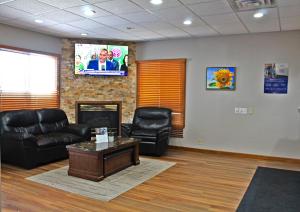 a waiting room with a couch and a tv at Days Inn by Wyndham West-Eau Claire in Eau Claire