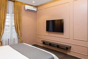 a bedroom with a bed and a tv on a wall at BON Hotel Emporium in Ughelli