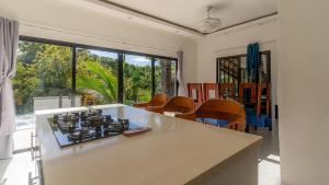 a kitchen with a stove top oven next to a table at Villa Palacio Verde Las terrenas in Las Terrenas