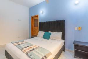 a bedroom with a large bed with a black headboard at Villa Palacio Verde Las terrenas in Las Terrenas