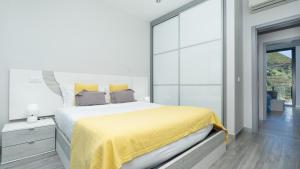 a bedroom with a large bed with a yellow blanket at Villa Stella by LovelyStay in Arco da Calheta +47 photos