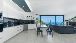 a kitchen and living room with a view of the ocean at Villa Stella by LovelyStay in Arco da Calheta