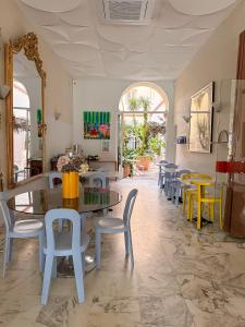 a room with tables and chairs and a mirror at Hôtel L'orque Bleue in Sète