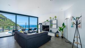 a living room with a couch and a view of the ocean at Villa Stella by LovelyStay in Arco da Calheta
