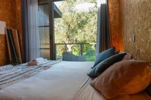 a bedroom with a large bed with a large window at Biovilla Sustentabilidade in Palmela +16 photos