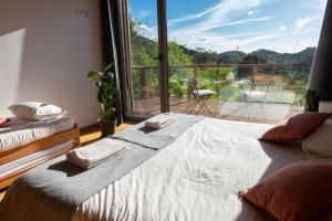 a bedroom with a bed and a large window at Biovilla Sustentabilidade in Palmela